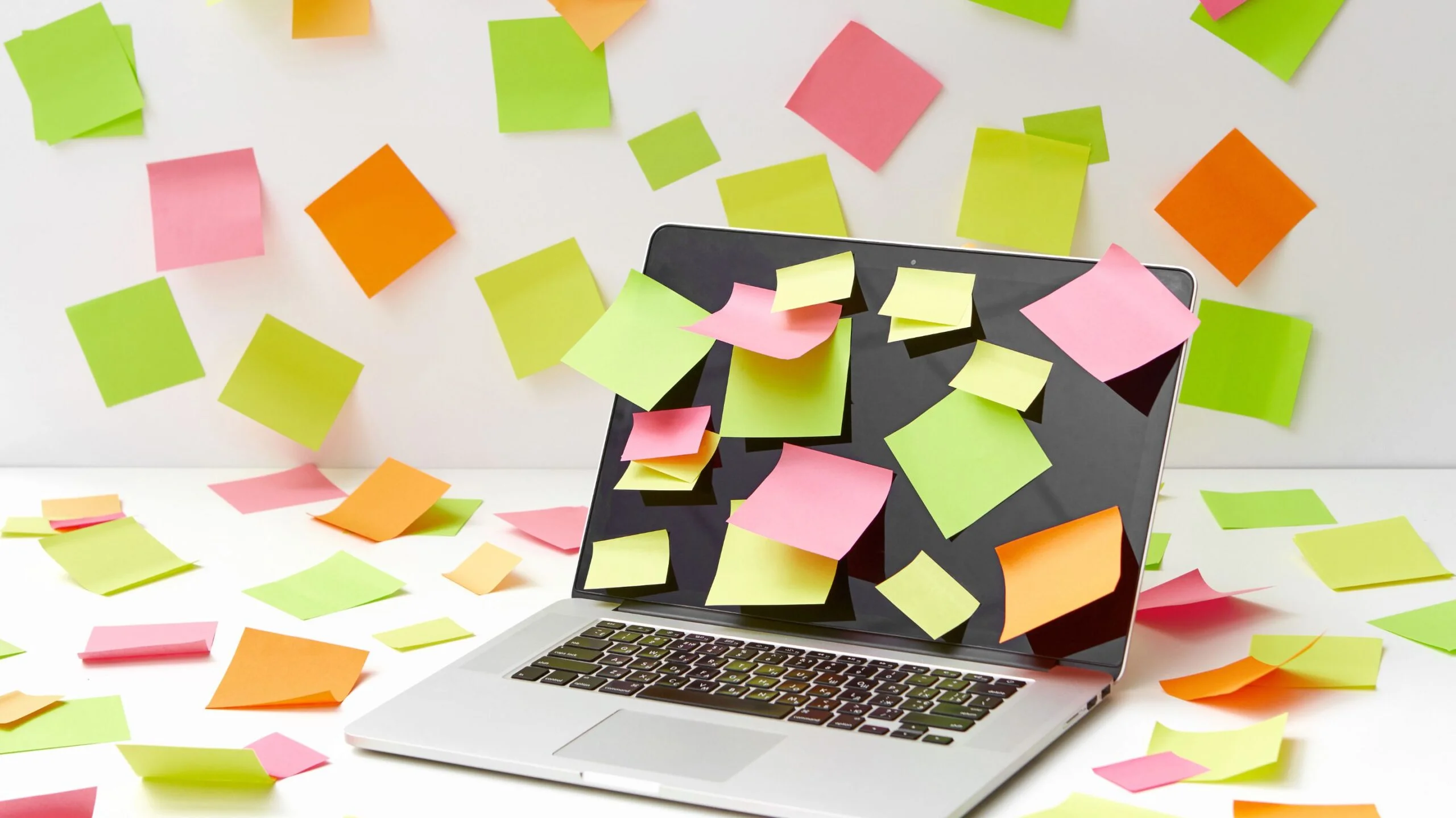 Colorful sticky notes attached on a laptop`s display and all over the place